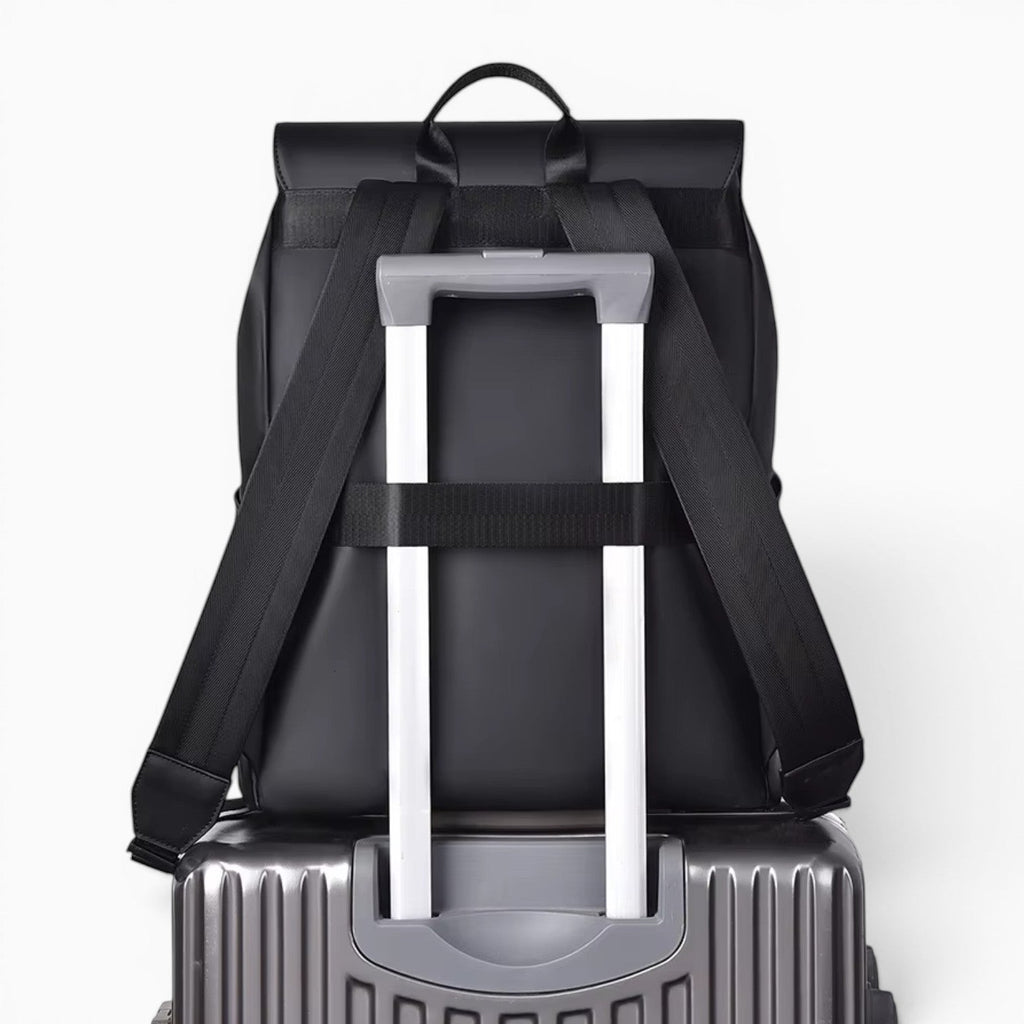 Sac à dos Le Voyage Prestige noir en PVC avec sangle pour valise, idéal pour les voyages et le travail.