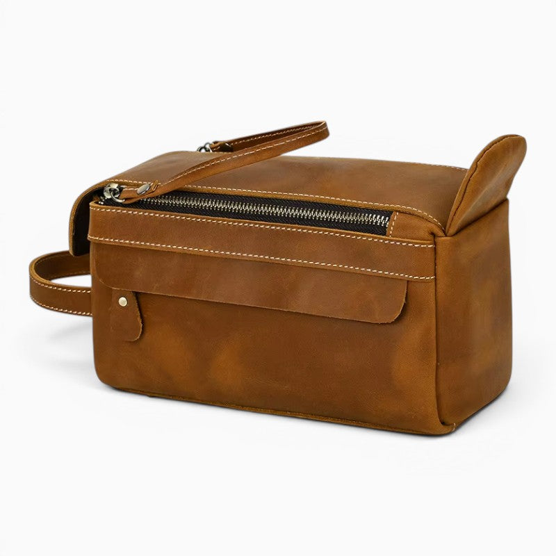 Le Voyage Prestige sac de voyage compact en cuir marron avec fermeture éclair et poche extérieure.