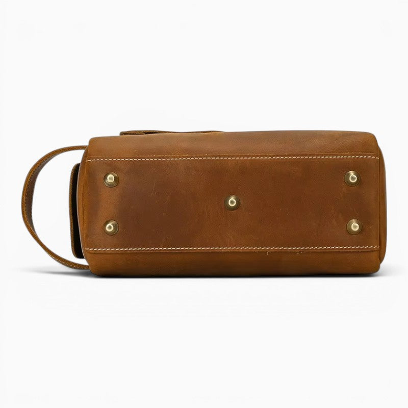 Le Voyage Prestige Sac de voyage compact en cuir marron avec pieds métalliques et poignée latérale